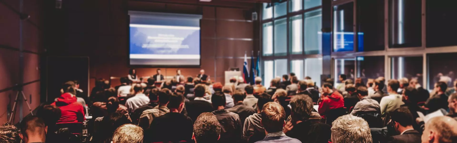 Kongress Vortrag mit Bildschirm und Zuhörenden bei Kongress