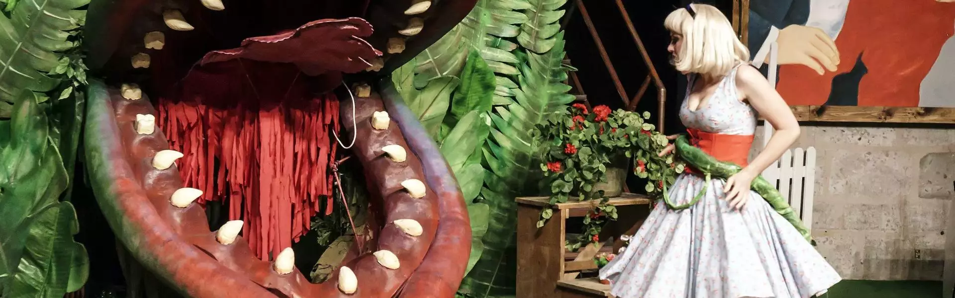 Schauspielerin mit Bühnenbild Schauspielerin spielt Szene neben großer Pflanze bei einem Theaterstück