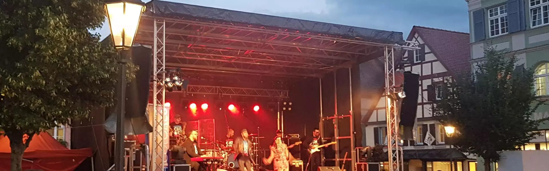 Freilichtbühne in Kommune Freilichtbühne mit Beleuchtung, Band und Publikum in einer Kommune